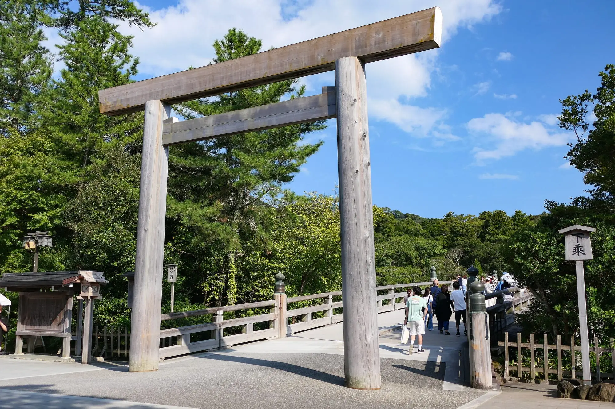 伊勢神宮内宮、宇治橋の手前に立つ素木の鳥居。奥に橋と杉木立が続く